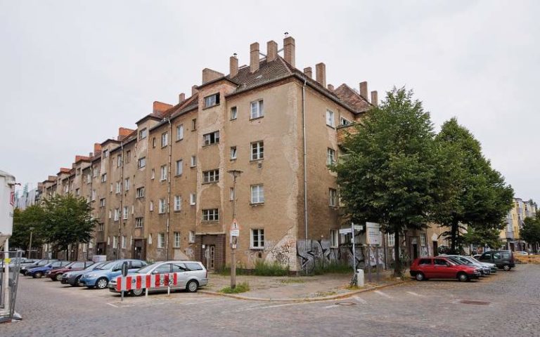 Vor der Sanierung bot der Block einen traurigen Anblick großflächig bröckelte der graue verwitterte Putz von der Fassade ab. - Bild: © Christian Werner, Gewobag