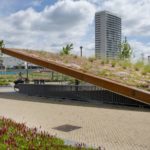 Einer der Blickfänger des Bahnhofsareals ist der überdachte Fahrradraum mit seinem auffallend schrägen, hochwertig begrünten Dach. - Bild: © Nophadrain