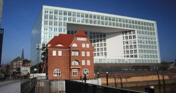 (Dach-)Sanierung des denkmalgeschützten „Alten Zollamtes“ HafenCity Hamburg Sanierter Backsteinbau vor moderner Architektur.